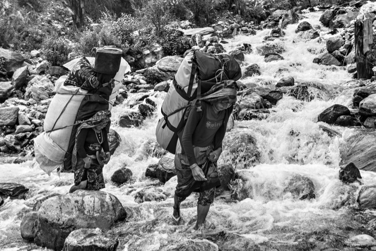 Mujeres  porteando en el valle del Khumbu grandes cargas con material de alguna expedición al Everes