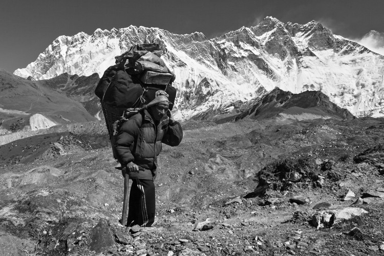 Porteador sherpa con la espectacular cara sur del Lhotse al fondo.