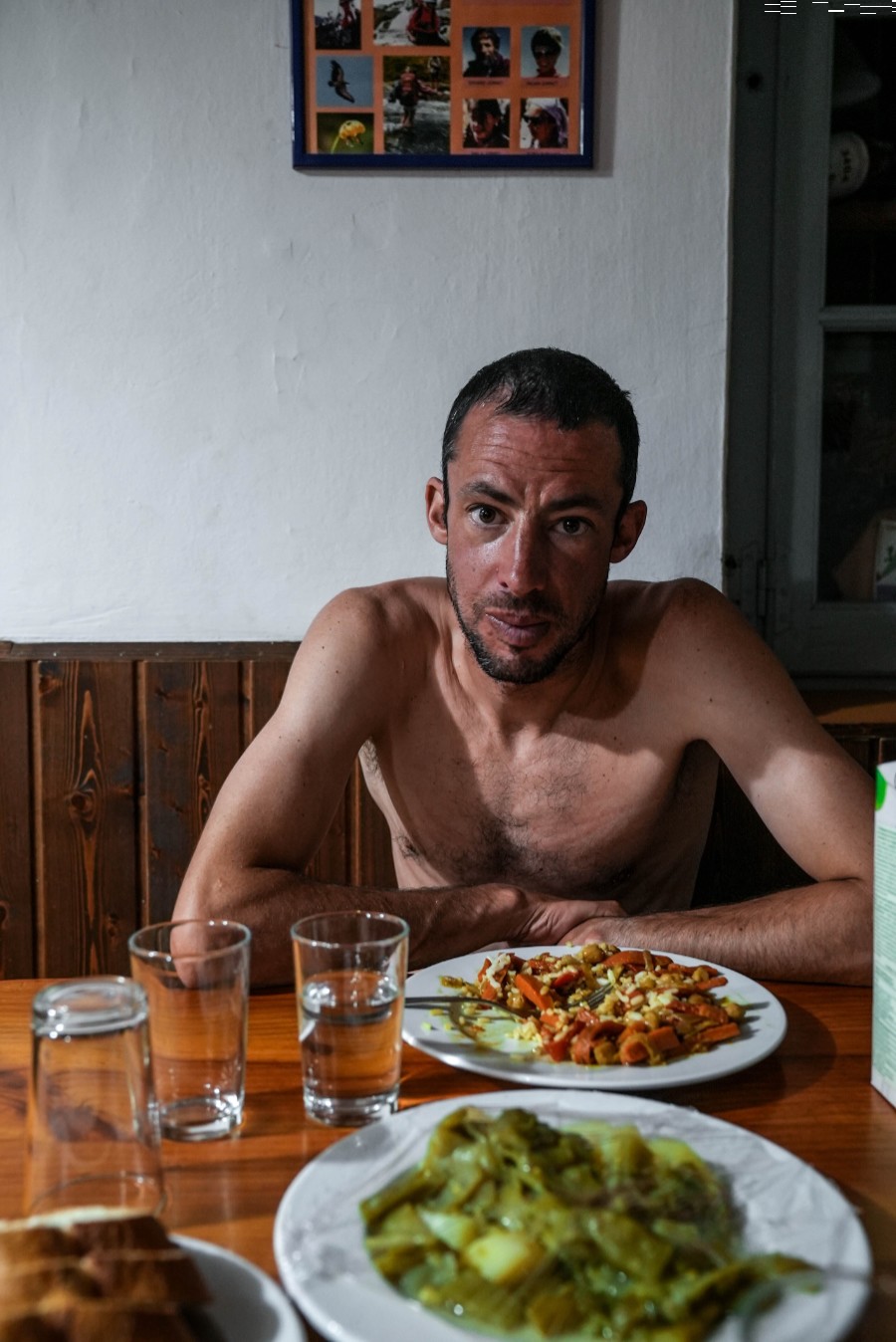Kilian Jornet, en un refugio durante la travesía pirenaica. Detrás, póster de cuando niño realizó con padres y hermana GR11 Foto: NNormal. David Ariño